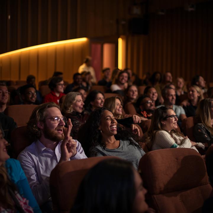 An audience watching a film together in a darkened theater