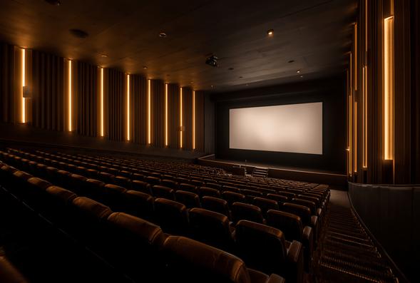 An empty cinema auditorium lit only by the screen